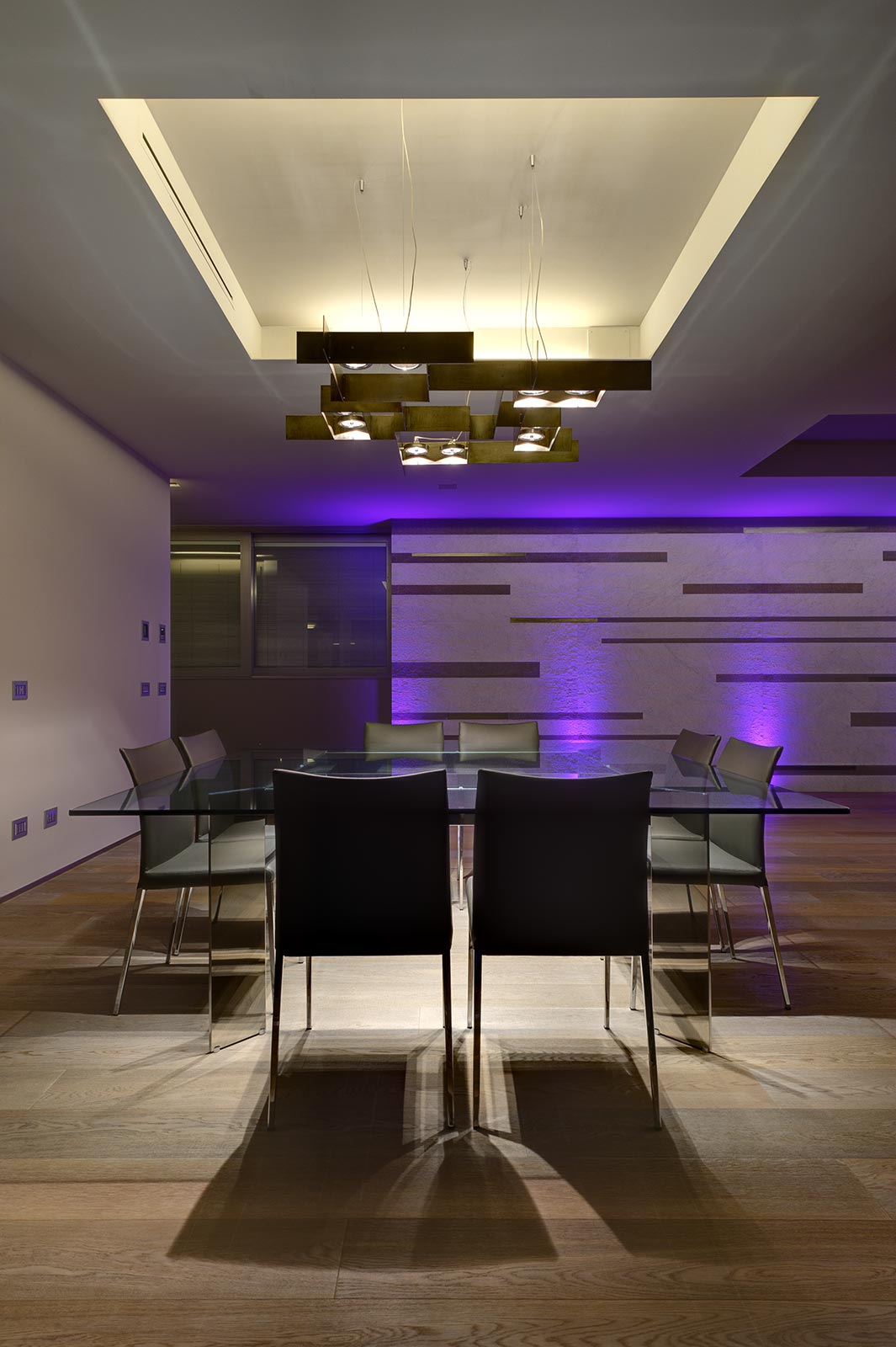 Sala da pranzo con illuminazione scenografica e parete retroilluminata