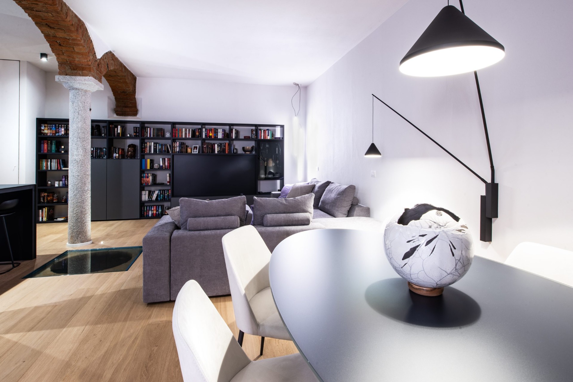 Zona living con libreria su misura e tavolo da pranzo