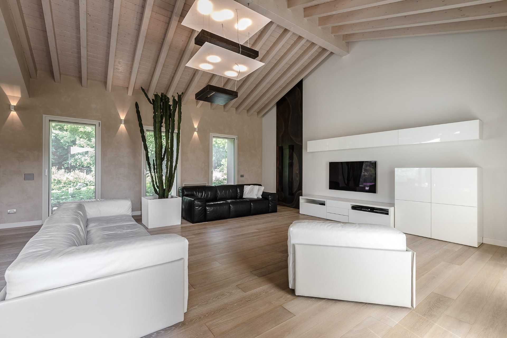 Living luminoso con soffitto a capriate in legno e arredi minimal