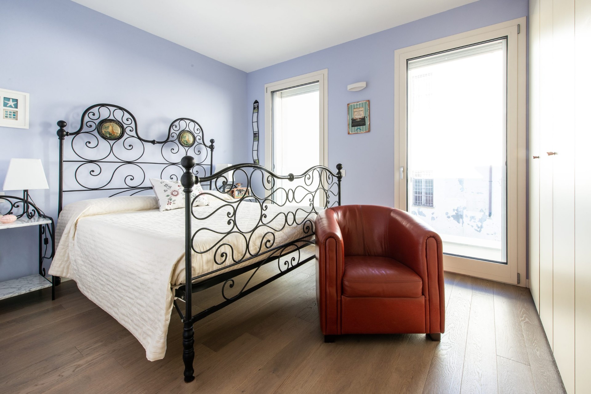Camera da letto con parete azzurra e letto in ferro battuto