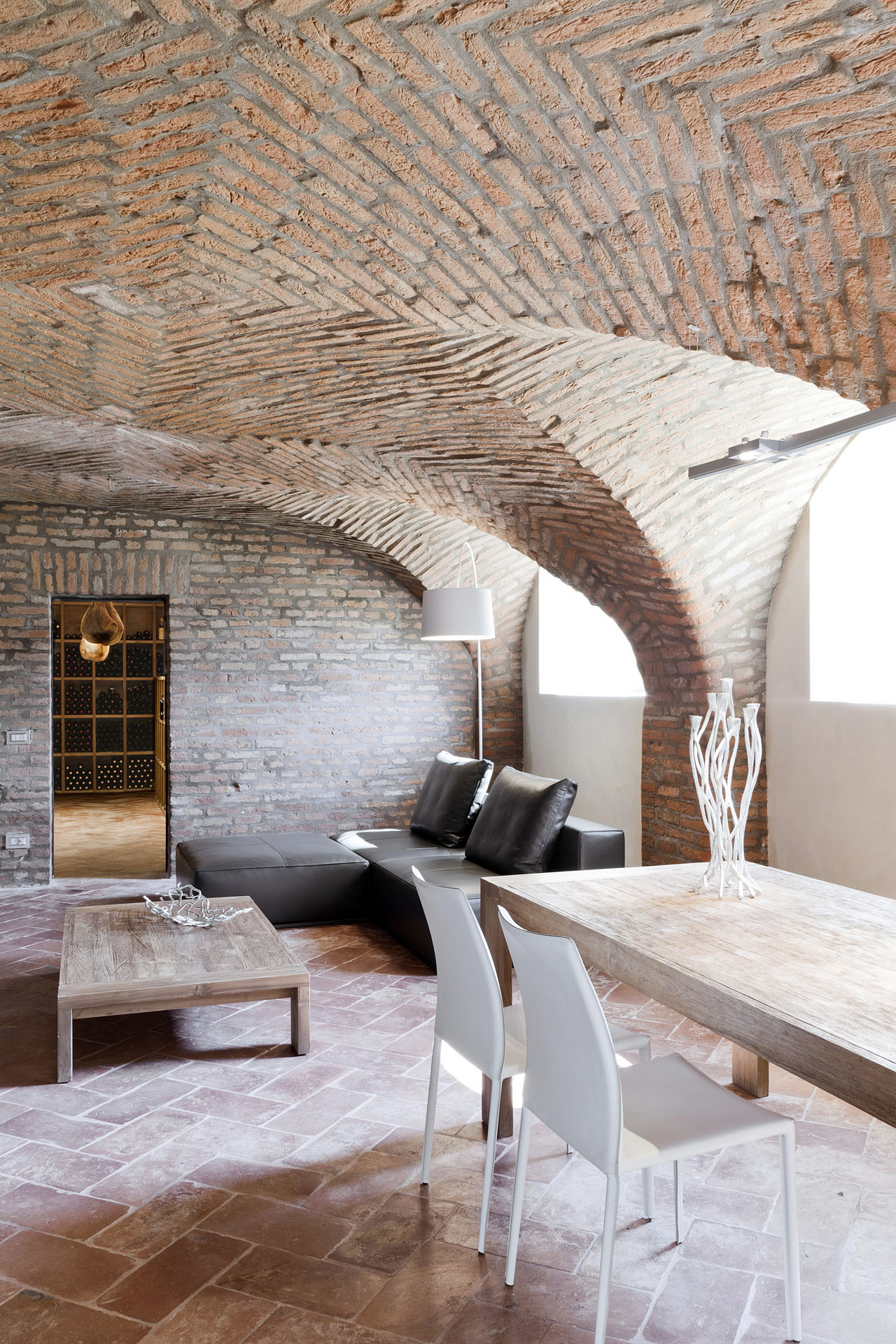Sala pranzo sotto volte in mattoni con accesso alla cantina