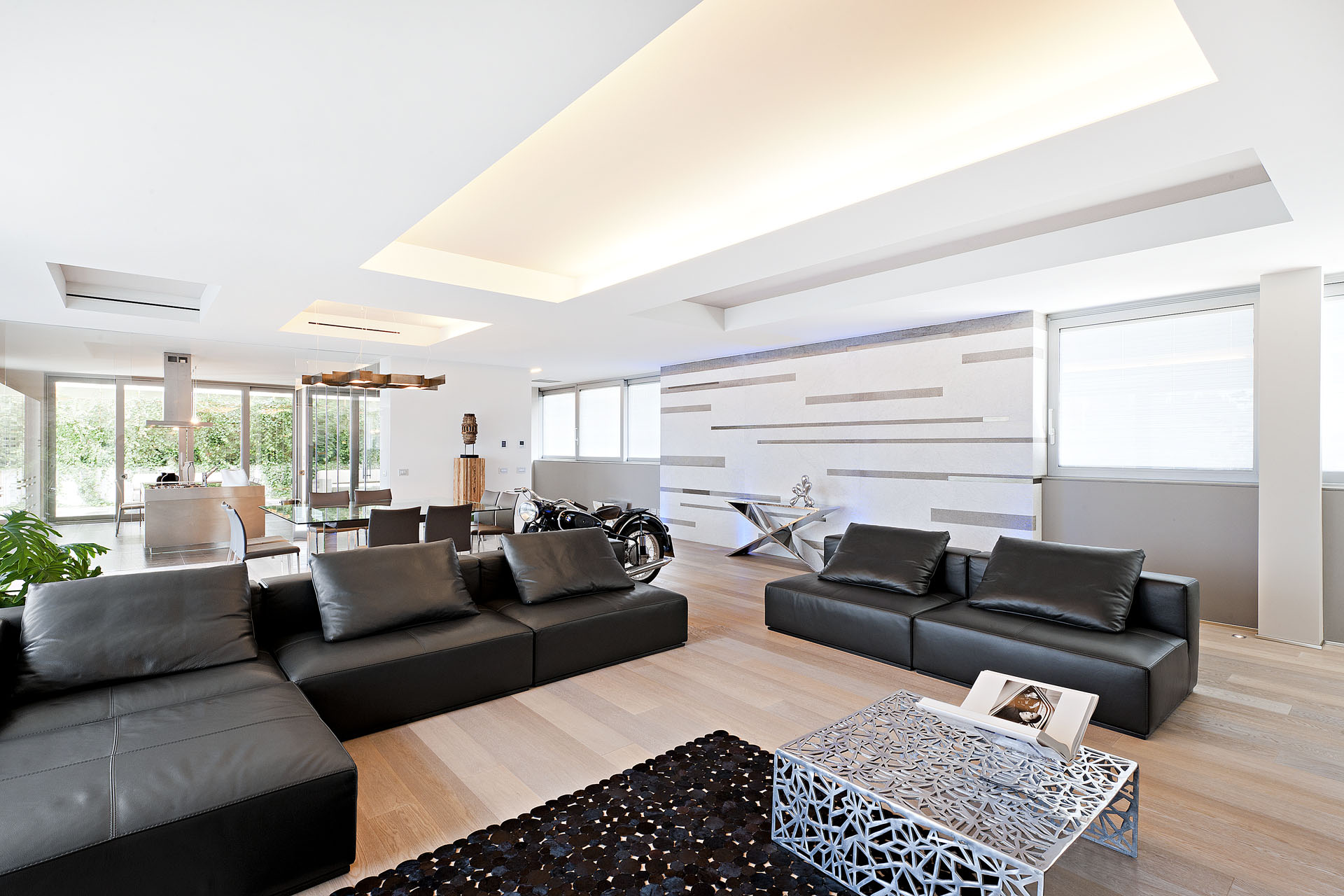 Salone dell'attico con divani in pelle e parete decorativa a fasce